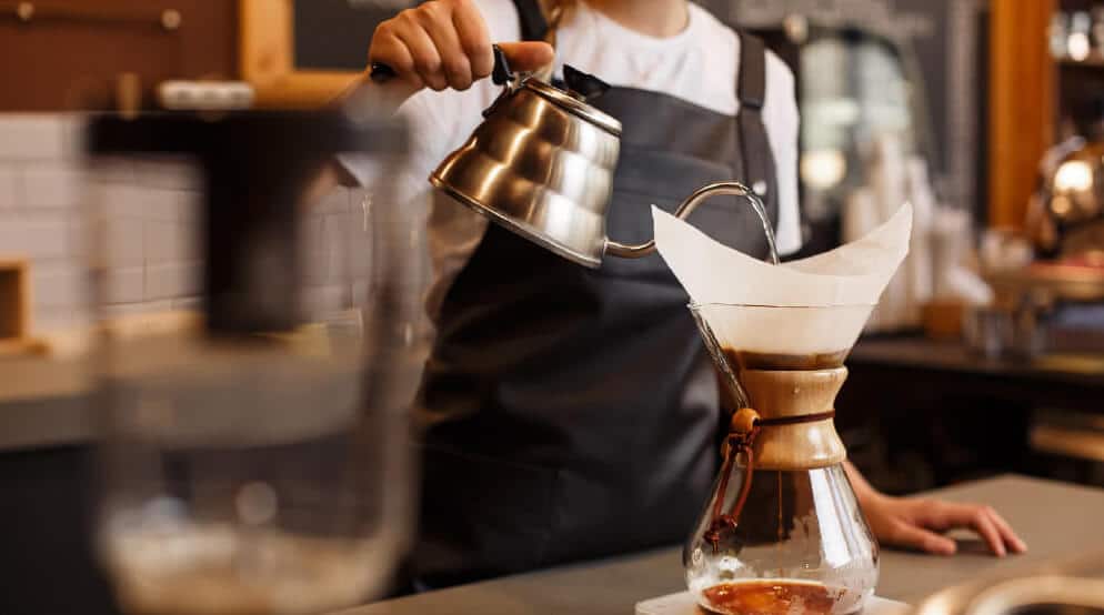 A man pours coffee in a cappuccino glass inside a coffee shop near Graham, Washington.